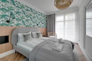 sypialnia z dużym łóżkiem z biało-zieloną tapetą w obiekcie Havana Premium Family Stay by Lion Apartments Sopot w mieście Sopot