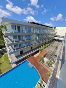 ein Apartmenthaus mit einem Pool neben einem Gebäude in der Unterkunft Dafam Resort Belitung in Tanjungbinga
