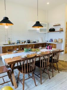 une cuisine avec une grande table et des chaises en bois dans l'établissement Chon's Dock Homestay & Apartment For Lease, à Phan Thiết