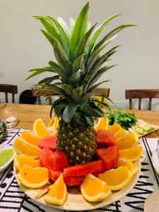 un ananas sur une plaque de fruits sur une table dans l'établissement Chon's Dock Homestay & Apartment For Lease, à Phan Thiết