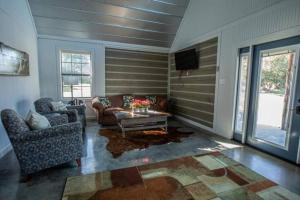 a living room with two couches and a tv at Saddle Creek Cabins in Roznov