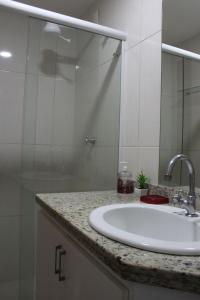 y baño con lavabo y ducha acristalada. en Aconchegante Apartamento na Prainha, en Arraial do Cabo