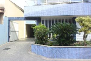 una casa con una pared de azulejos azules y plantas en Aconchegante Apartamento na Prainha en Arraial do Cabo