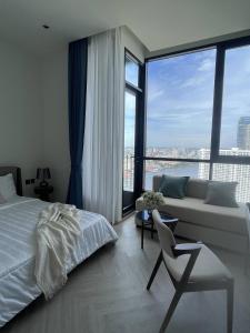 a bedroom with a bed and a couch and windows at Luxury River View in Bangkok