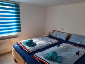 ein Schlafzimmer mit 2 Betten und Handtüchern darauf in der Unterkunft Pension Kerstin in Warnemünde
