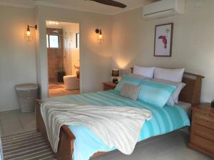a bedroom with a large bed and a bathroom at Goody's Guest House in Toogoom