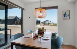 een eetkamer met een tafel en stoelen en een groot raam bij Havnehusene, Lejl, 37 in Slagelse