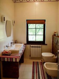 bagno con lavandino, servizi igienici e finestra di Relax villa a Pirnove
