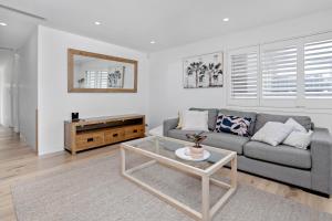 a living room with a couch and a table at Collaroy Beachfront Escape - New Listing in Collaroy