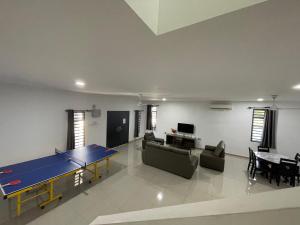 una sala de estar con mesa de ping pong. en homestay port dickson - elaine, en Port Dickson