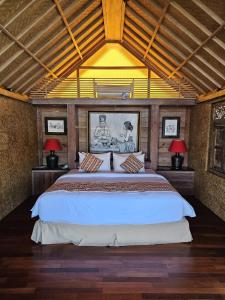 a bedroom with a large bed with two lamps at I Guci Home in Munduk
