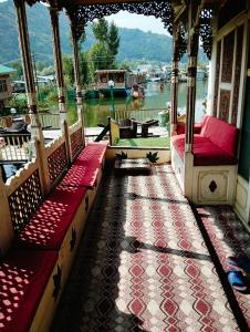 a porch with red benches and a view of the water at THE Bombay Heritage Group of House boat in Srinagar