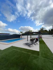 a patio with two chairs and a swimming pool at Villa Gerudo in Crevillente