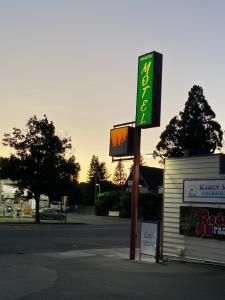 una señal de gasolinera al lado de una calle en Johnston's Motel, en Garberville