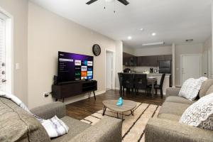 uma sala de estar com dois sofás e uma televisão em Historic Apartment Downtown SA em San Antonio
