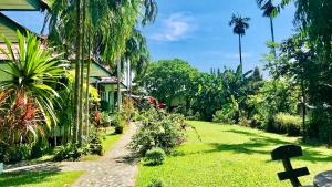 een tuin met een kruis naast een huis bij Swiss Chalet Garden, Pool Resort in Krabi town