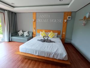 1 dormitorio con 1 cama con un cartel en la pared en Anita dream house, en Khao Sok