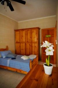 um quarto com uma cama e uma mesa com uma flor em Masri Accommodation em Il-Pergla
