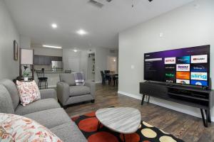uma sala de estar com uma grande televisão de ecrã plano em Historic Apartment Downtown SA em San Antonio