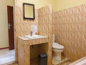 uma casa de banho com um WC, um lavatório e um espelho. em Thyesza Hotel em Ambarita