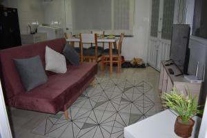 a living room with a red couch and a table at Tranquilo y Acogedor Apto en Fusagasugá. in Fusagasuga