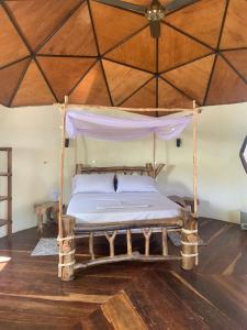 Ce lit se trouve dans un dortoir doté d'un plafond en bois. dans l'établissement Mi casa es tu casa Glamping, à Capurganá