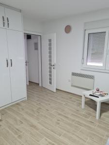 Vrnjačka BanjaにあるAPARTMANI DJERISILOの白い部屋(テーブル、テーブル・シドックス・シドックス付)
