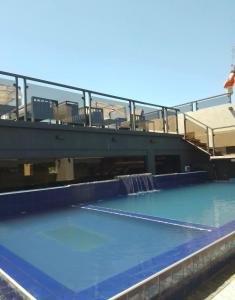 a large swimming pool with a water fall at Bello monoambiente a metros del aeropuerto in Colonia Mariano Roque Alonso