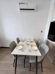 a white table with chairs and plates on it at Sihanouk City View Condominium in Sihanoukville