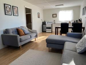 un salon avec deux canapés et une cuisine dans l'établissement Dora Creek Cottage, à Dora Creek