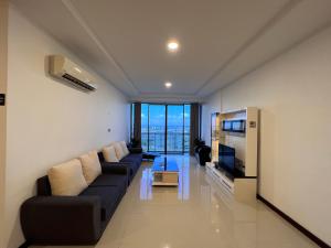 a living room with a couch and a television at Super comfy 1800sqft Condo in Imperial Suites Boulevard Mall in Kuching