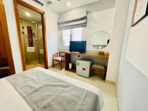 a bedroom with a bed and a desk and a mirror at KEN HOTEL in Ho Chi Minh City