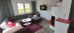 un salon avec un canapé et une télévision dans l'établissement Ferienhaus Markgraf, à Elend
