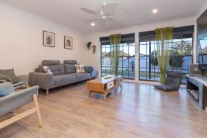 una sala de estar con un sofá y una mesa en 8 Elizabeth Parade, en Forster