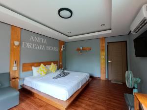 1 dormitorio con 1 cama blanca grande y TV en Anita dream house, en Khao Sok