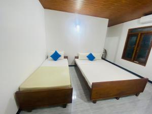 two twin beds in a room with at A4 Residence Colombo Airport -by A4 Transit Hub - free pickup & drop Shuttle Serviceトランジットホテルトランジットホテル in Katunayaka