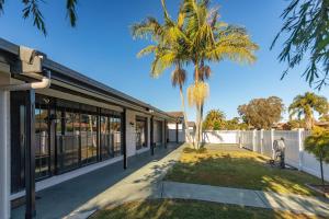 una palmera delante de un edificio en 8 Elizabeth Parade, en Forster
