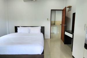 1 dormitorio con 1 cama blanca grande y espejo en Garden house in Aonang, en Krabi