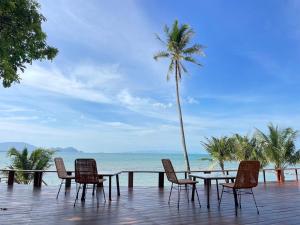 a table and chairs on a deck with a view of the ocean at X-Sea Khanom Harbor Bay Resort in Khanom