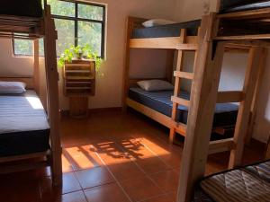 um quarto com 3 beliches e uma janela em Hostal Tribu Malinalco em Malinalco