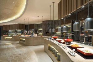 un restaurante con una línea de buffet con comida en The Westin Zhujiajian Resort, Zhoushan, en Zhoushan