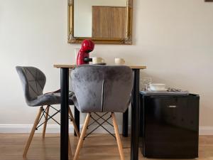 a table with two chairs and a desk with a mirror at Aparthotel Cracow in Kraków