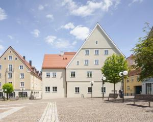 a group of buildings in a courtyard with benches at Küchlinhaus in Memmingen