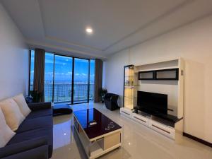 een woonkamer met een blauwe bank en een televisie bij Super comfy 1800sqft Condo in Imperial Suites Boulevard Mall in Kuching