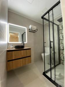 a bathroom with a sink and a mirror and a toilet at La Lunita in Valverde