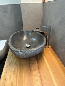 ein Badezimmer mit einem Steinwaschbecken auf einem Holzboden in der Unterkunft Chrys appartamenti in Valfurva
