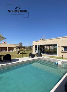 a swimming pool in front of a building at Vi Hosting Cabañas Premium in Salta