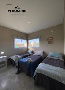 Habitación con 3 camas y 2 ventanas en Vi Hosting Cabañas Premium en Salta