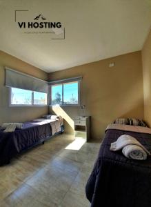 1 dormitorio con 2 camas y ventana en Vi Hosting Cabañas Premium en Salta