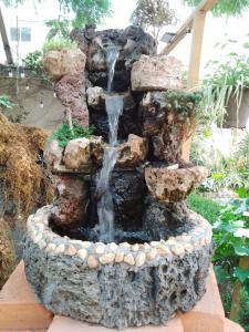 a stone fountain with a waterfall in a garden at Casita del Árbol in Mexico City